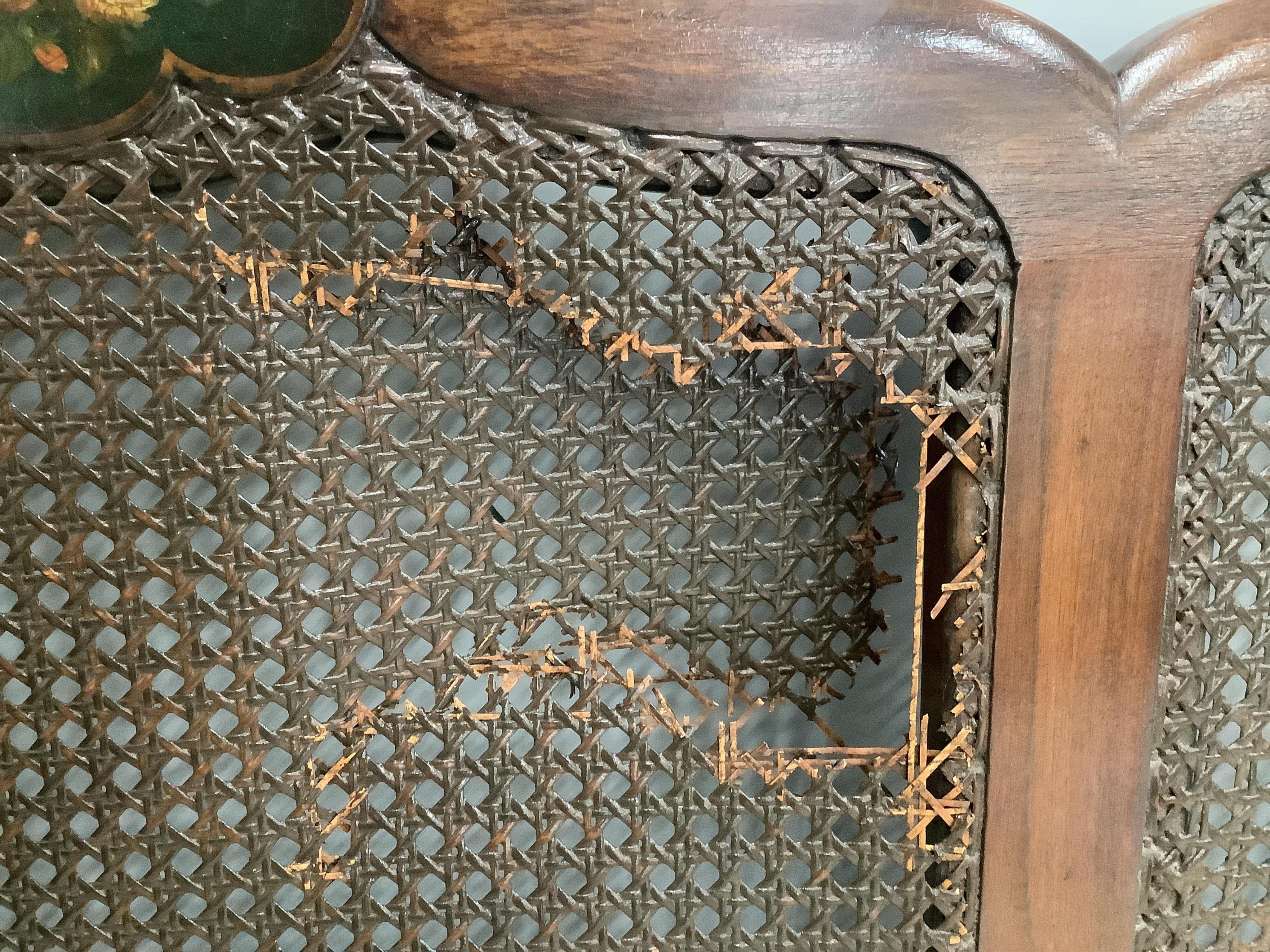 An early 20th century part painted walnut three piece bergere suite, settee width 186cm, depth 78cm, height 80cm. Condition - fair, although one cane panel is damaged and needs repair